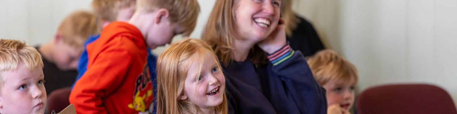 At a children's Book Festival event children  are smiling and laughing.