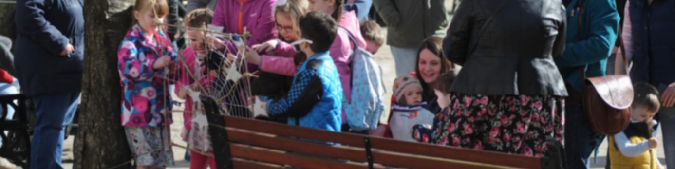 Families gathered outdoors for a Children' Book Festival event.