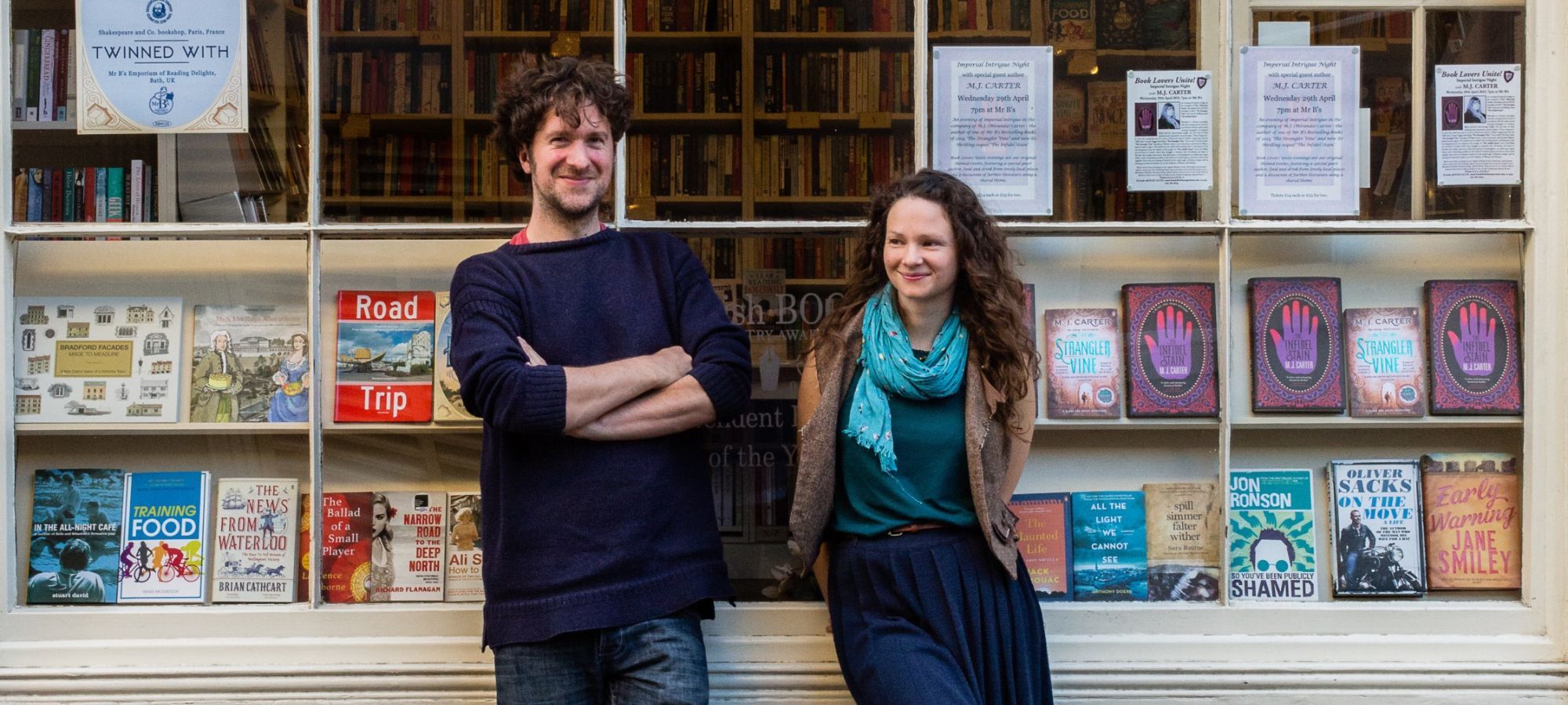 Ben Please and Beth Porter of the Bookshop Band stand outside a bookshop.