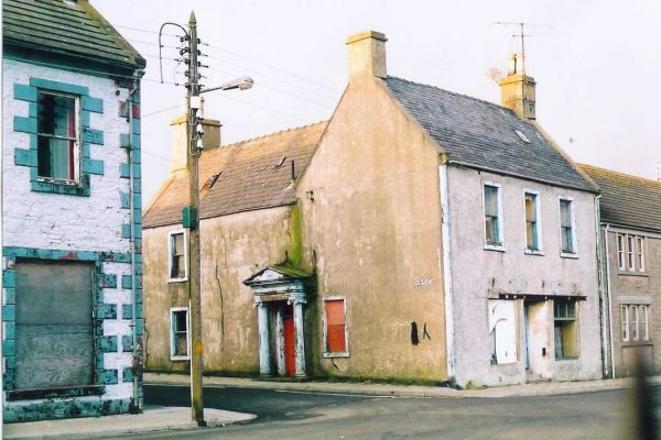 Old side view photo of no.11 North Main St, Wigtown. The building is run down and derelict.