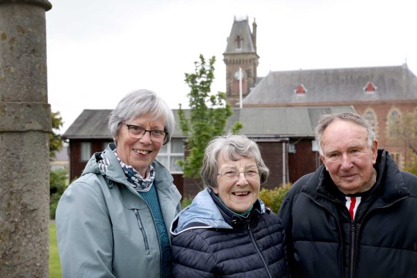 Original Book Town Committee Members, left to right: Sandra MacDowall, Meta Maltman, Donald King standing in front of the Wigtown County Buildings.