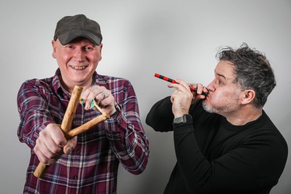 Mike Stirling and  Craig Graham are holding a slingshot and a blow pipe.