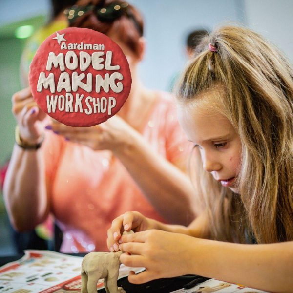 Young children are sitting making models out of clay as part of an Aardman Model making Workshop.