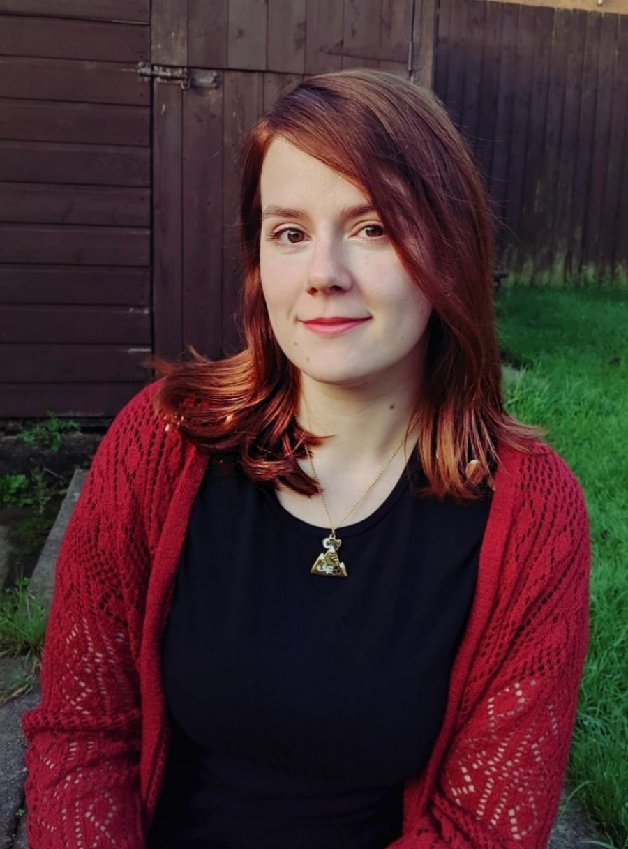 Headshot of Alex Foulkes sitting in a garden.