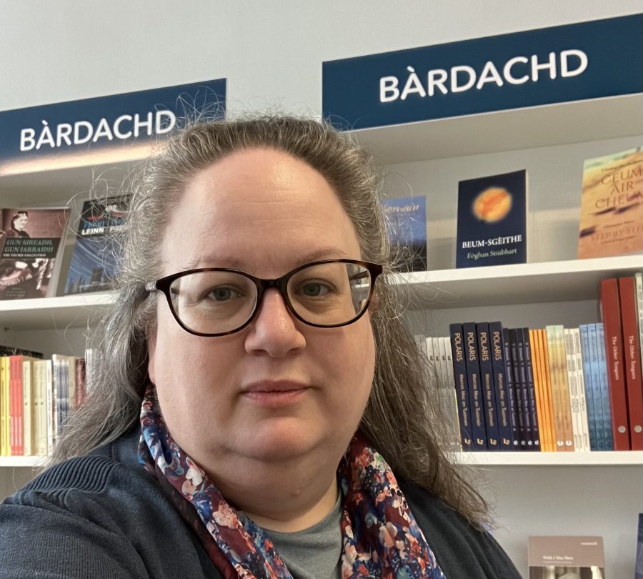 Alison Lang, Director of Scottish Books Council standing in front of a bookshelf.